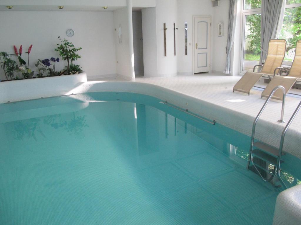 a swimming pool with blue water in a house at Hotel Germania in Bad Wörishofen
