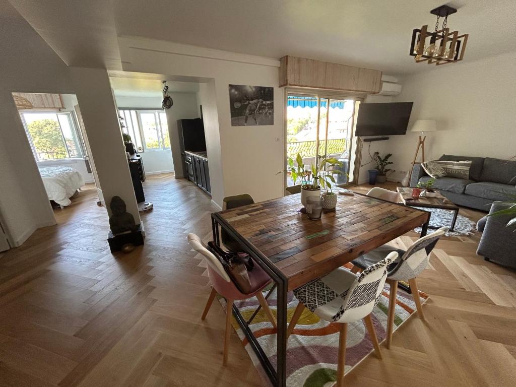 un salon avec une table et des chaises en bois dans l'établissement Appartement 60m2 à 500m des plages, à Antibes