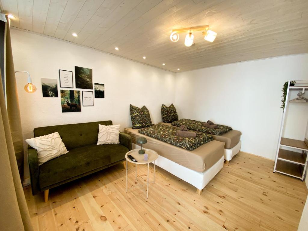 a living room with a bed and a couch at Wanderglück - Naturnah zum Wohlfühlen & Wandern in Gleisweiler