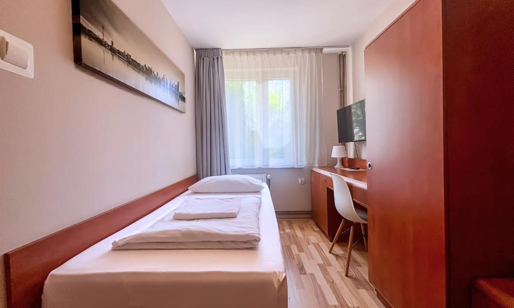 a bedroom with two beds and a desk and a window at City Hostel in Szczecin