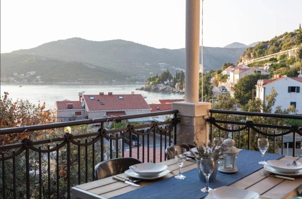 einen Tisch auf einem Balkon mit Blick auf das Wasser in der Unterkunft Apartments Fig&Olive in Zaton
