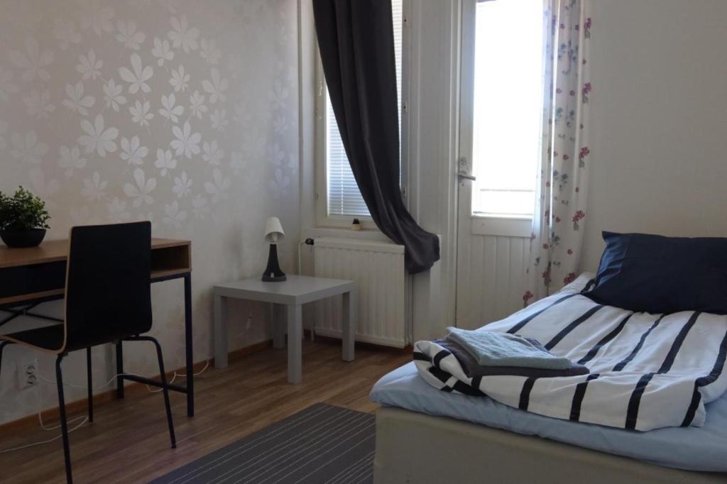 a bedroom with a bed and a desk and a window at Apartment Vanhatie, 3mh in Pyhäjoki