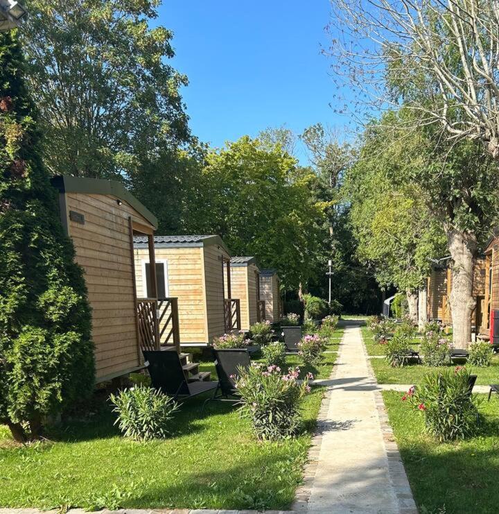 une rangée de maisons sur un trottoir dans une cour dans l'établissement Paris Camping Ile du Roi, à Triel-sur-Seine