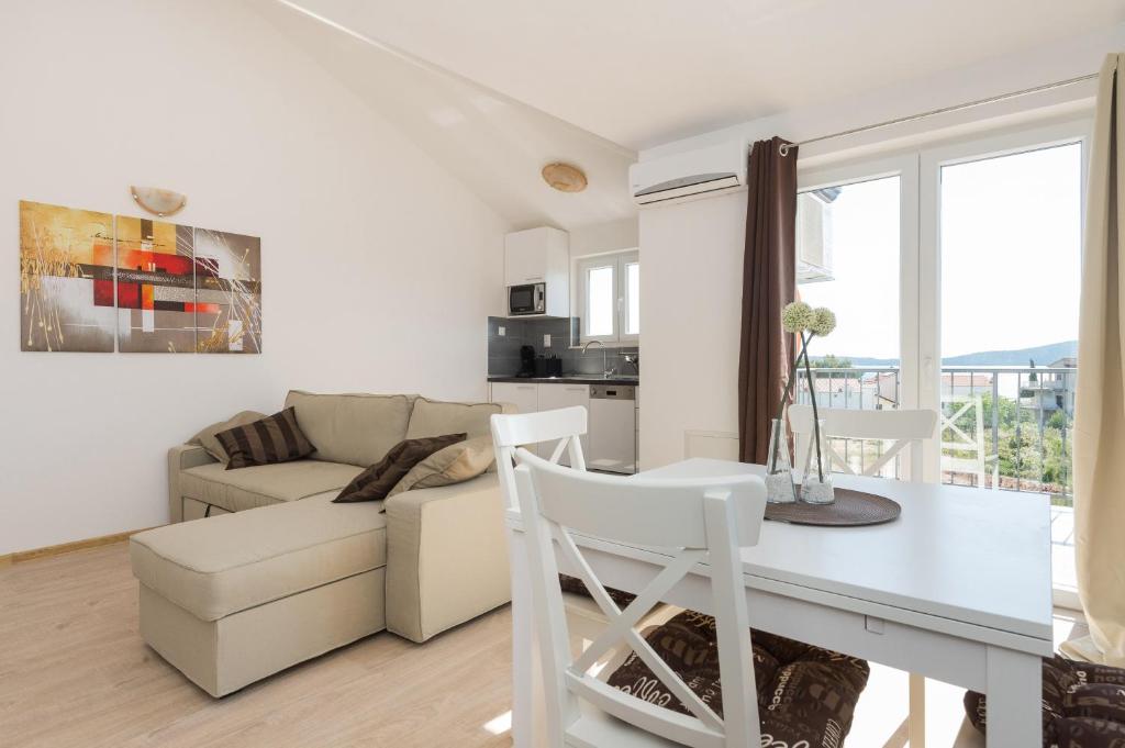 Biały salon ze stołem i kanapą w obiekcie M.G Apartments w mieście Brodarica