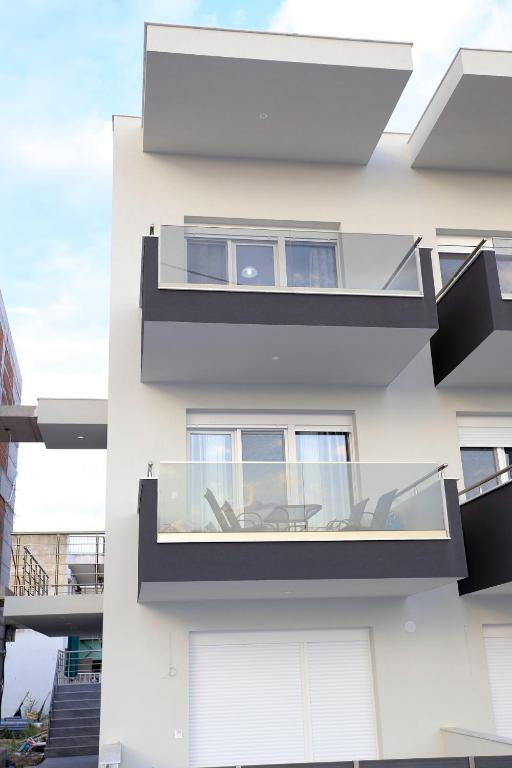 a facade of a white building with a glass balcony at Chroidis Appartment in Sozopoli
