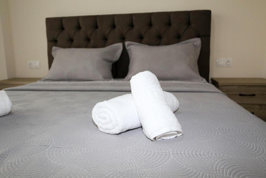 two rolls of white towels sitting on a bed at Chroidis Appartment in Sozopoli
