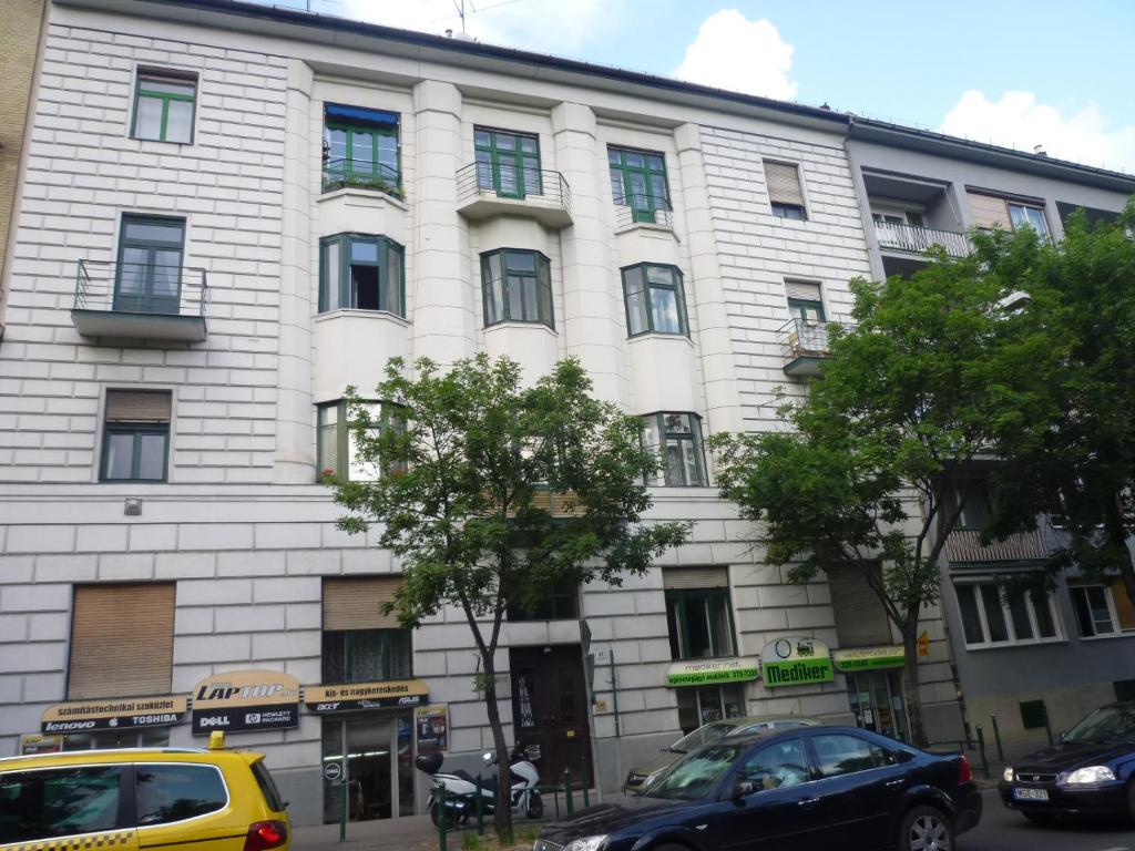 a white building with cars parked in front of it at Retro Apartment in Budapest