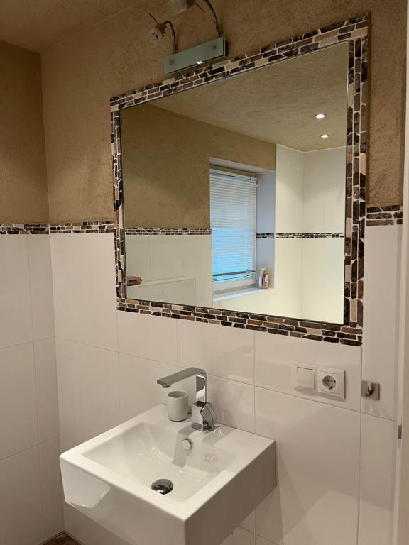 ロイタッシュにあるApartment Nalaの洗面台と鏡のある白いバスルーム