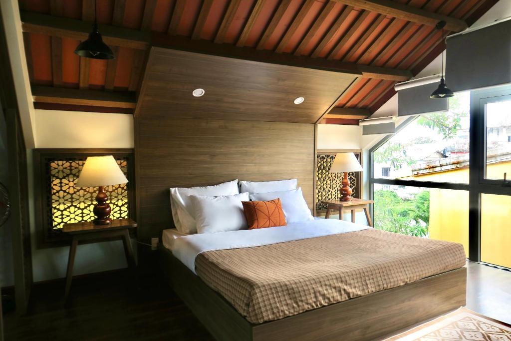 a bedroom with a large bed with two lamps on tables at Một Nhà Thơ Homestay in Hương Trà