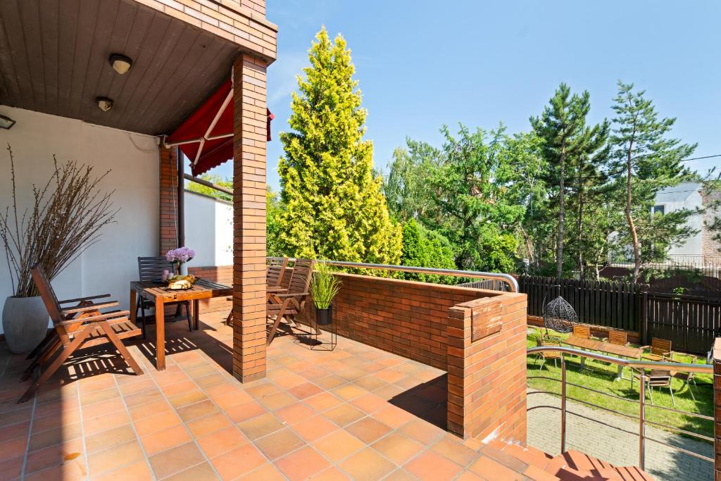 a patio with a fence and a table and chairs at Urban Spa House Jacuzzi, Sauna, Taras & Grill ! No Parties in Warsaw