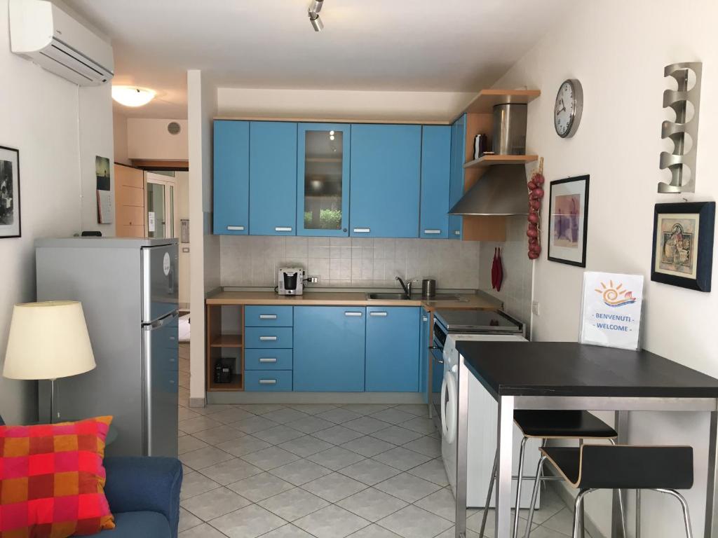 eine Küche mit blauen Schränken und einer schwarzen Arbeitsplatte in der Unterkunft Casa Vacanze "Marina Vecchia" in Senigallia