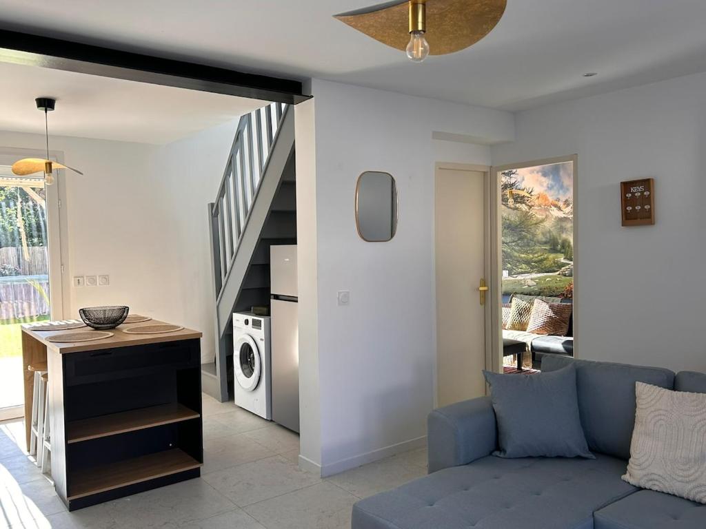 un soggiorno con un divano blu e una scala di Villa d'Aqui, cosy, piscine, jacuzzi a Béziers