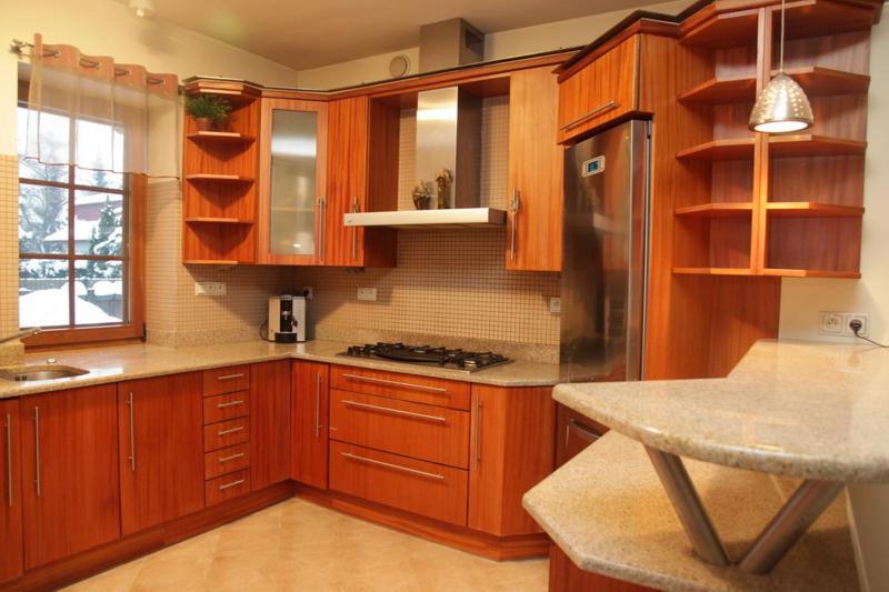 a kitchen with wooden cabinets and a stove top oven at Anna Maria in Łomianki