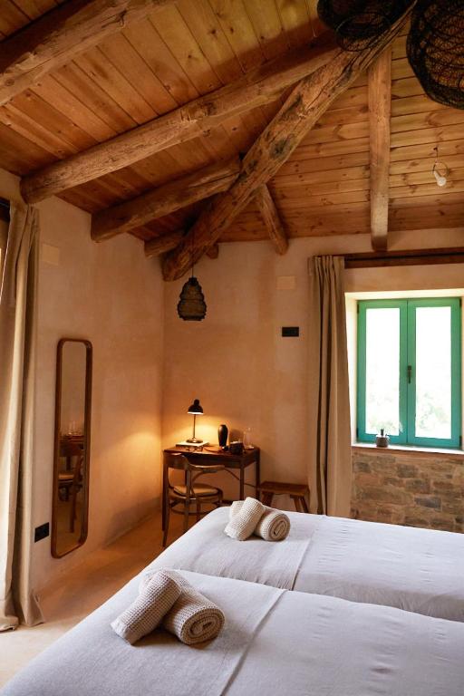 a bedroom with two beds and a table and a window at Casa Albaredo, Aldea Rural, Boutique Hotel, Retreat, in O Cebrero