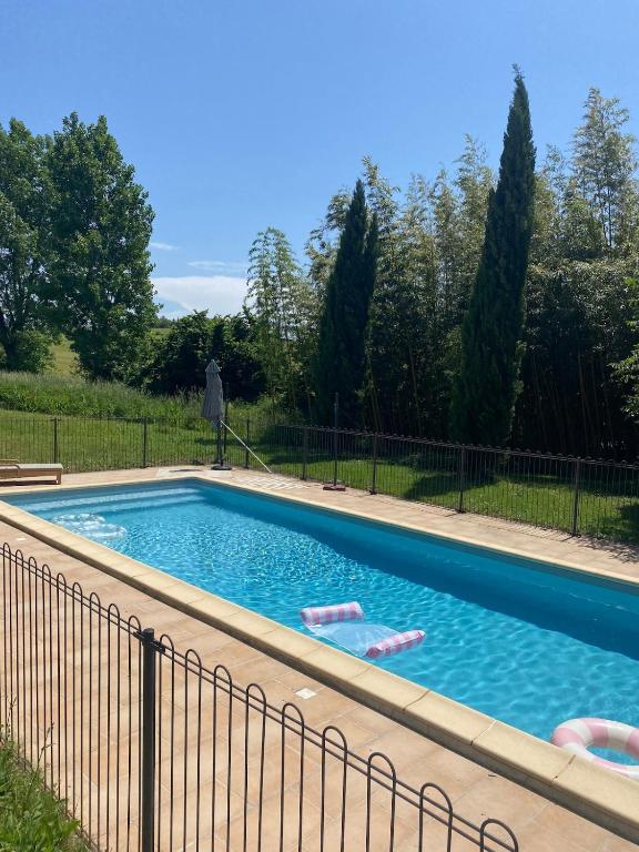 une piscine entourée d'une clôture dans l'établissement Souplassens, à Rieumajou