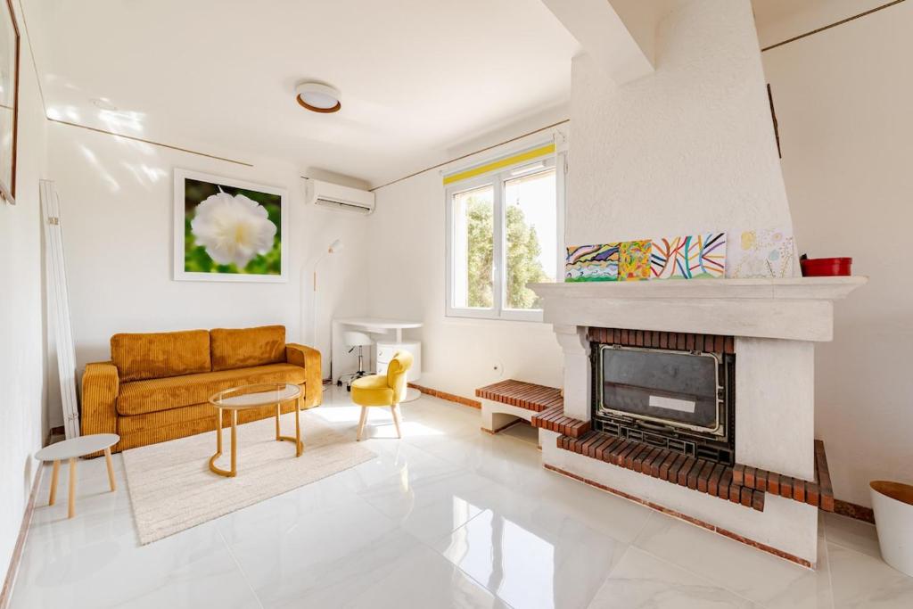 un salon avec un canapé et une cheminée dans l'établissement Maison indépendante 52 m2, clim, wifi et jardin, à La Londe-les-Maures