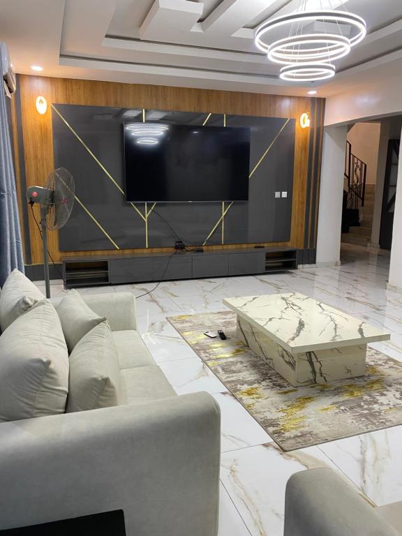 a living room with a couch and a flat screen tv at 2 bedroom duplex apartment in Ibadan