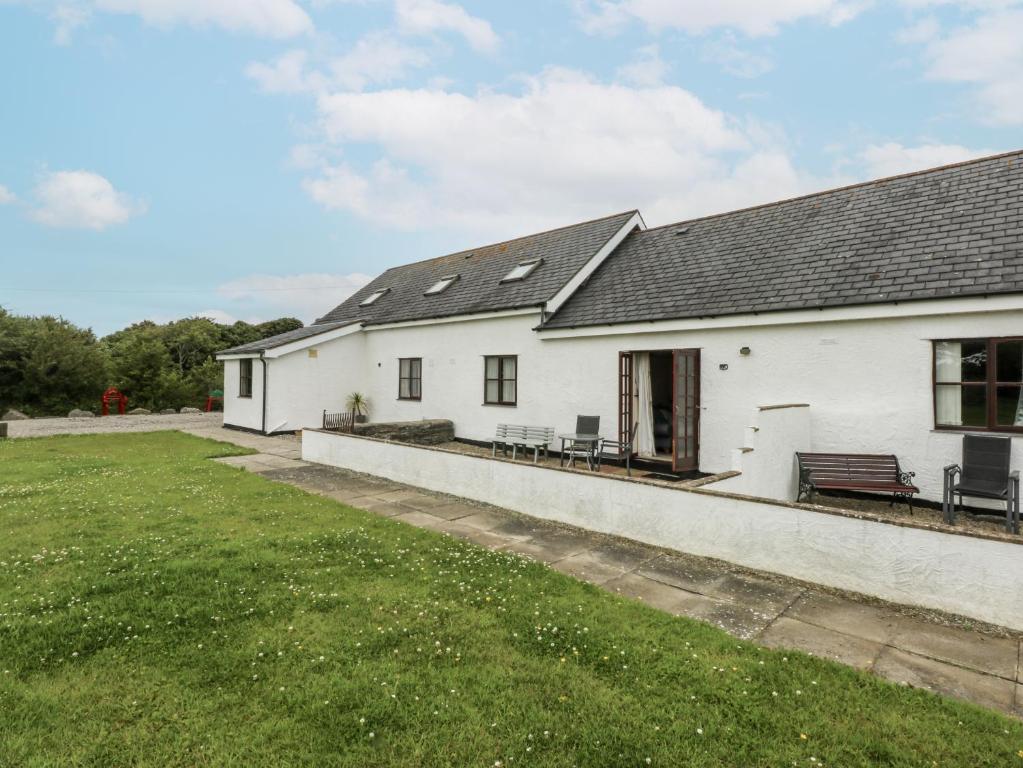 a white house with a lawn in front of it at Florence Cottage in Holyhead