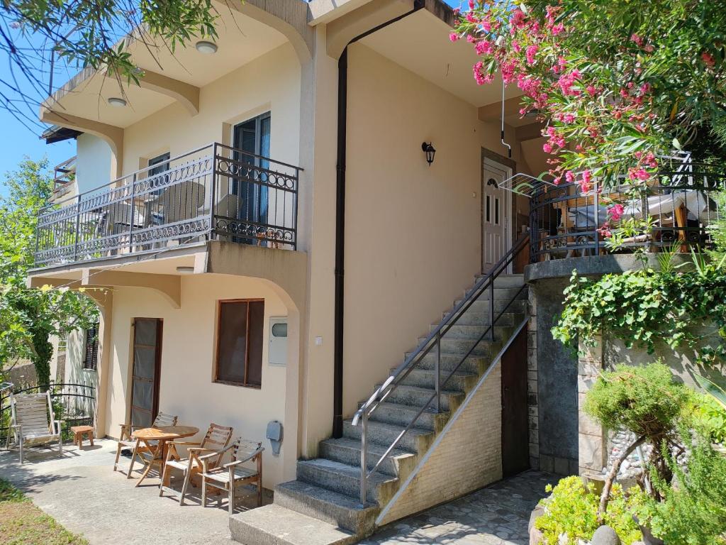 a house with stairs and a table and chairs at Apartman Čolović in Sutomore