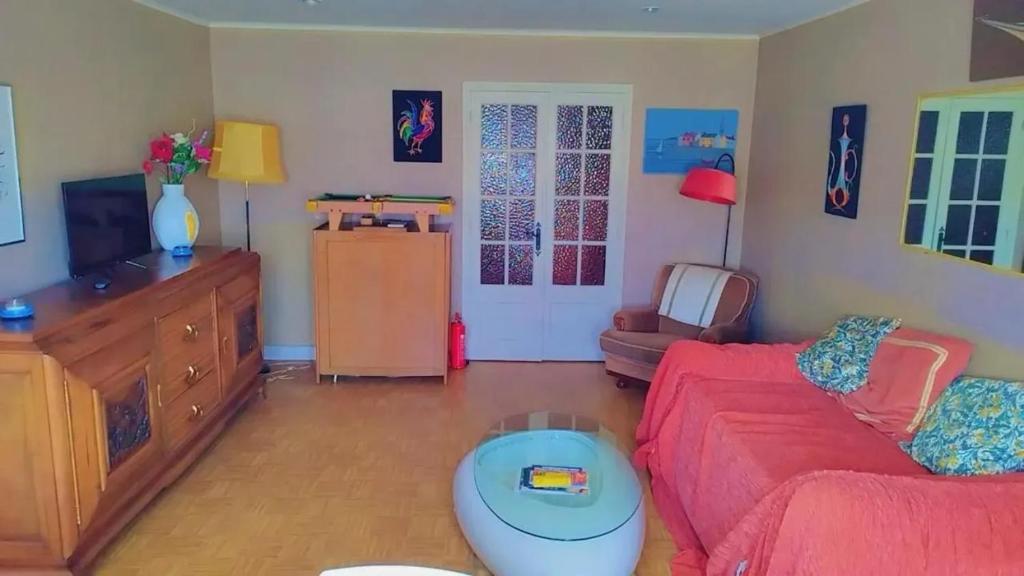 un soggiorno con un divano rosso e una TV di Maison familiale à Bugeat avec jardin accueillant a Bugeat