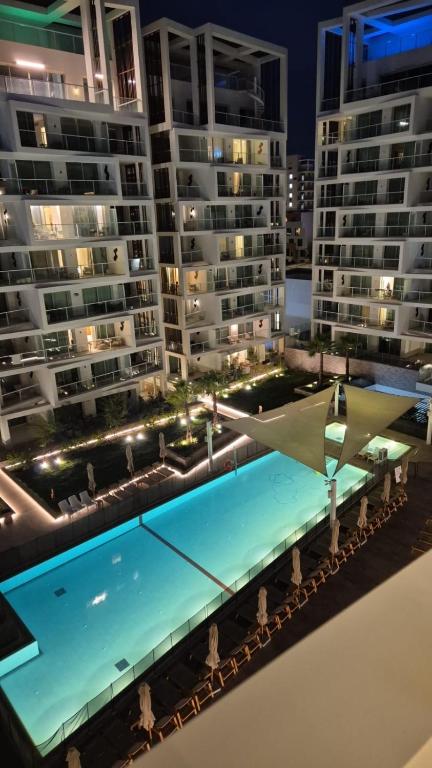 a swimming pool in front of some buildings at night at Beyond 42 Eilat in Eilat
