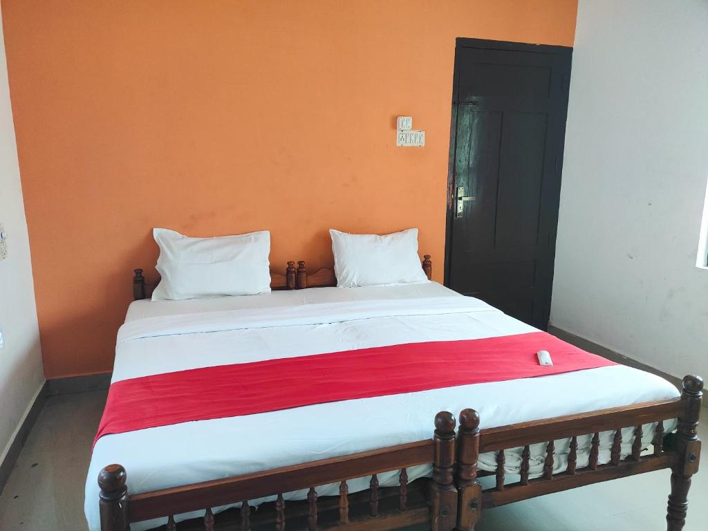 瓦尔卡拉Beach Combers Resort的床上有红白毯子