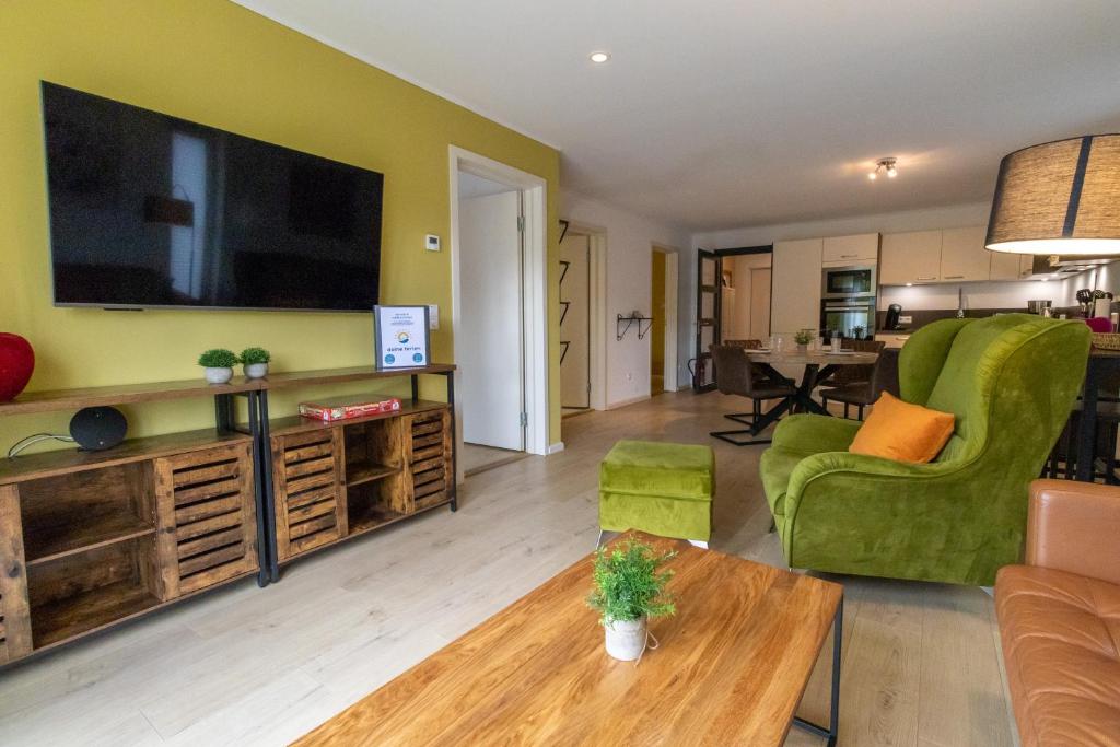 a living room with a large flat screen tv at Ferienwohnung Waldblick mit Terrasse und Garten - familienfreundlich in Heringhausen