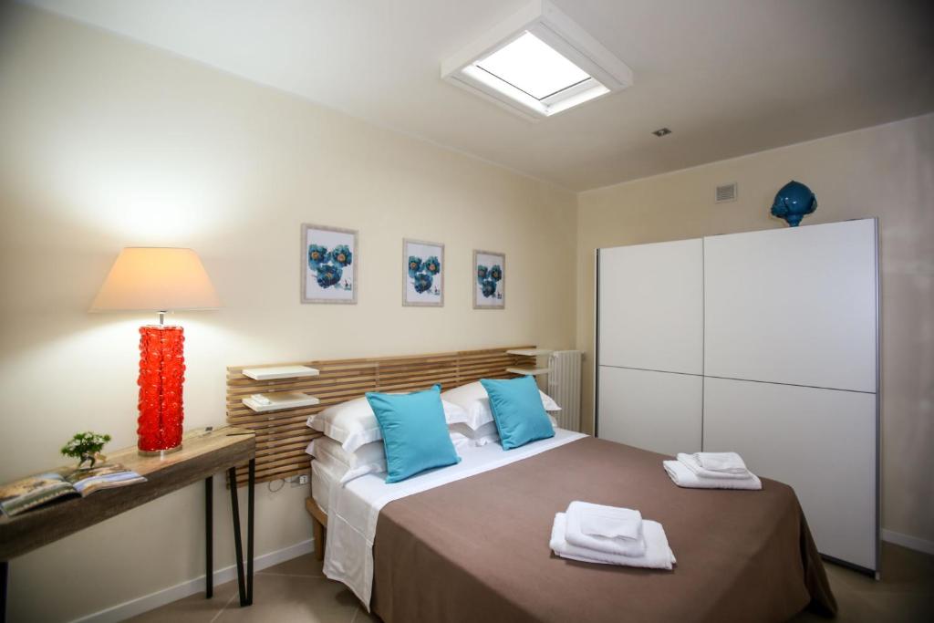 une chambre avec un grand lit avec des oreillers bleus dans l'établissement Villa Caraitria, à Martina Franca