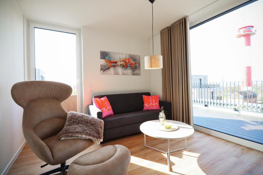 un salon avec un canapé et une table dans l'établissement Suite Relax 3.0 - Die elegante Ferienwohnung mit Dachterrasse, Meerblick und Sauna, à Fehmarn