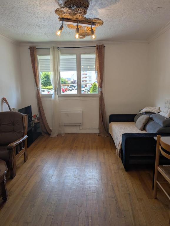 a living room with a bed and a window at Appartement rez de chaussée coup de cœur Confort et charme Parking gratuit in Roanne