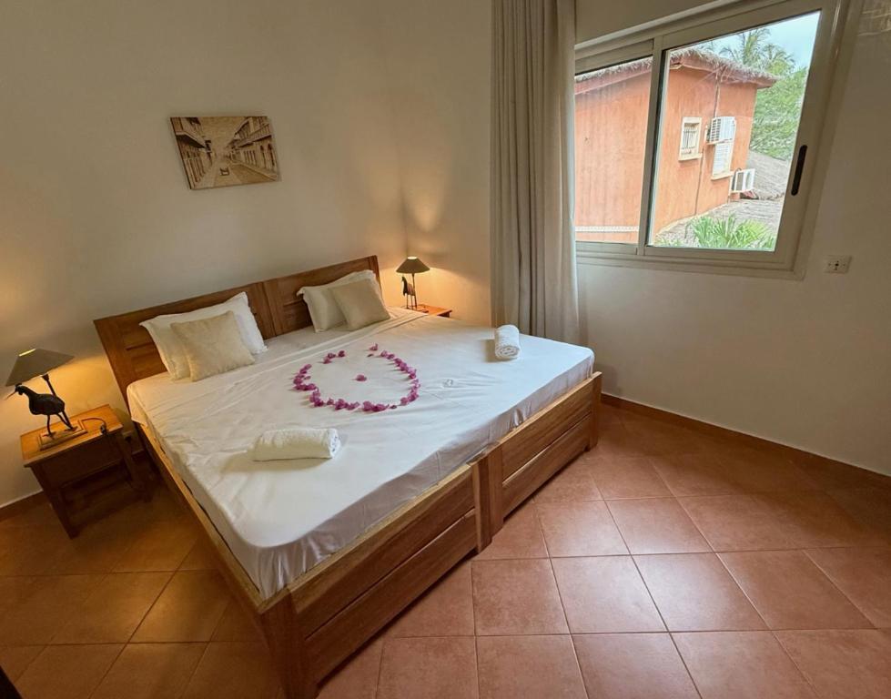 Un dormitorio con una cama grande con un arreglo floral. en Agence Adjana Resort - Résidence SAFARI VILLAGE, en Sali Tapé