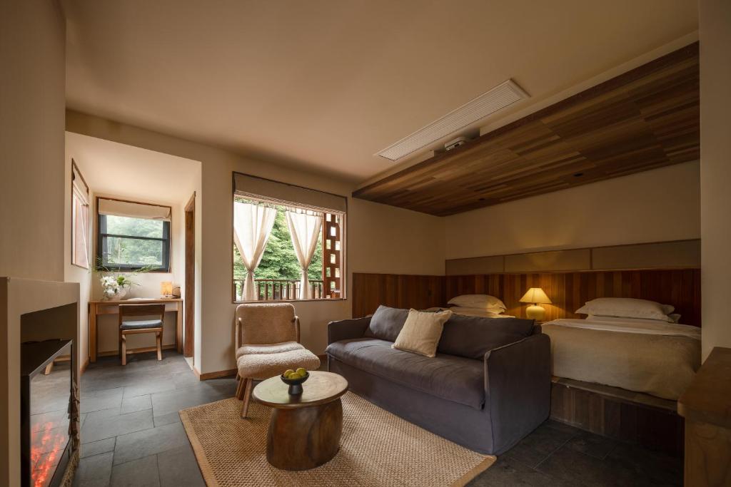 a living room with a couch and a bed at Hegu Retreat Qingcheng in Jiezi Ancient Town