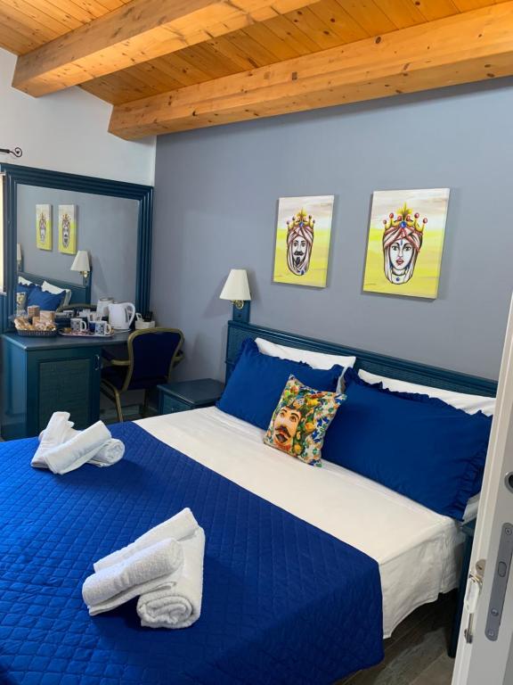 a bedroom with a blue and white bed and a desk at U muragliuni 2 in Lascari