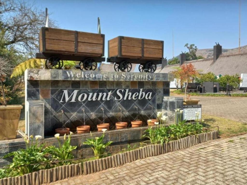 a sign with two train cars on top of it at Mount Sheba Rainforest & Resort in Pilgrim's Rest