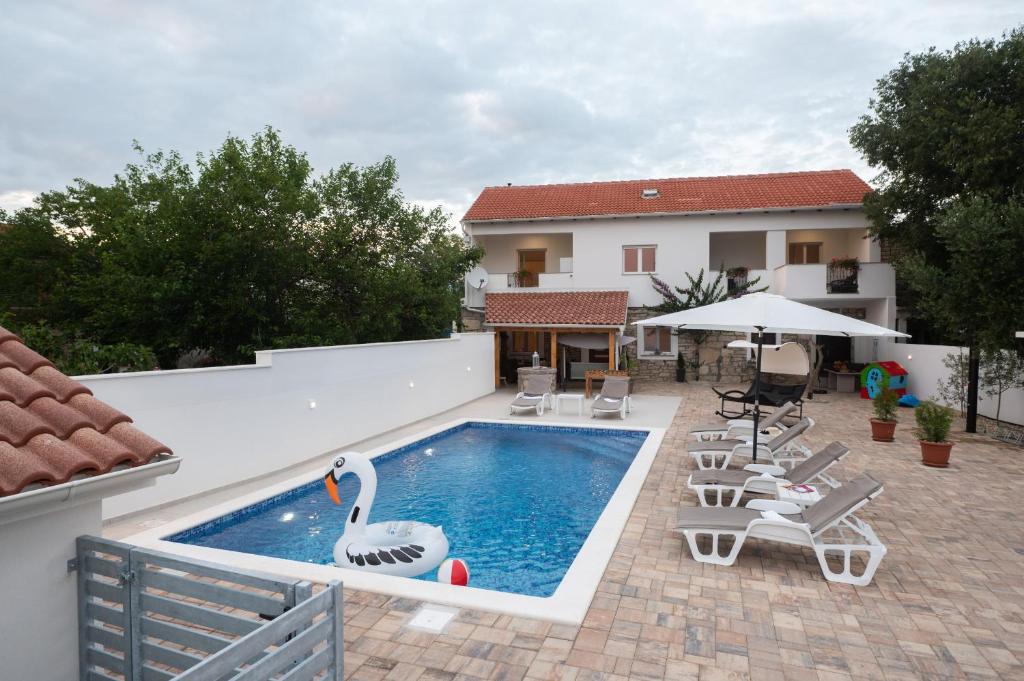 una piscina con cigno in un cortile di Holiday Home Lantina with pool a Pridraga