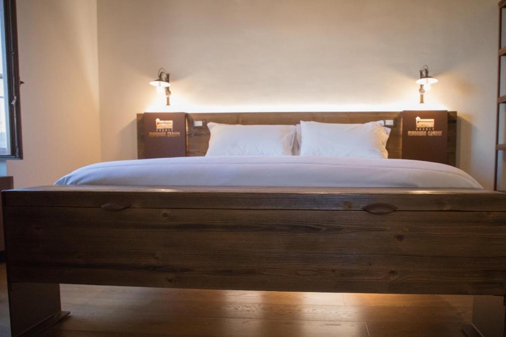 ein Schlafzimmer mit einem großen Holzbett mit zwei Kissen in der Unterkunft Casale Madonna Grande Wine Resort in Campomarino