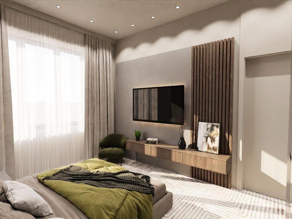 a bedroom with a bed and a flat screen tv at The Nest Hotel Baku in Baku