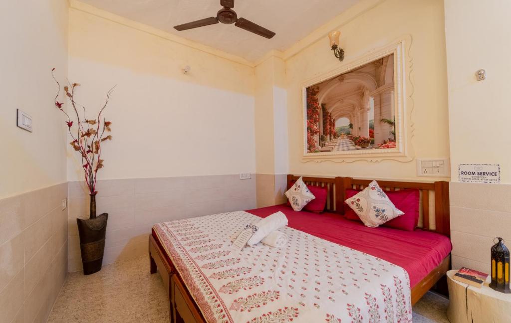 a bedroom with a bed with a red blanket at Travellers Village in Jaipur