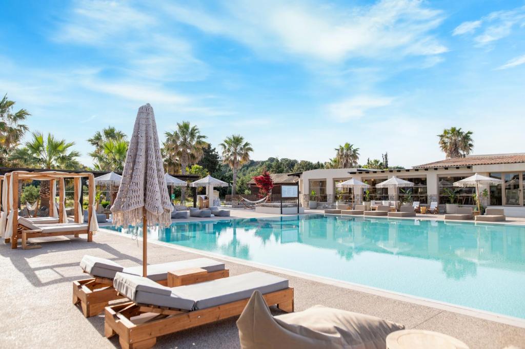 a pool at the resort with lounge chairs and umbrellas at Achilleas Beach Hotel Adults Only in Mastihari