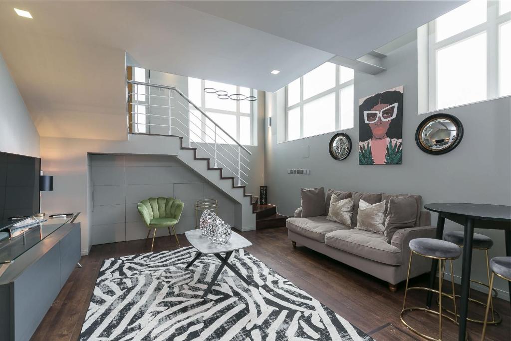 un soggiorno con un divano e una scala di The Editorial - Covent Garden By Frankie Says a Londra