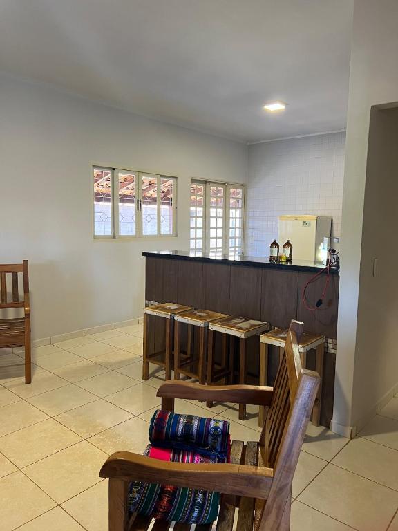 a room with a bar with wooden tables and chairs at Casa das Orquídeas Delfinopolis MG in Delfinópolis