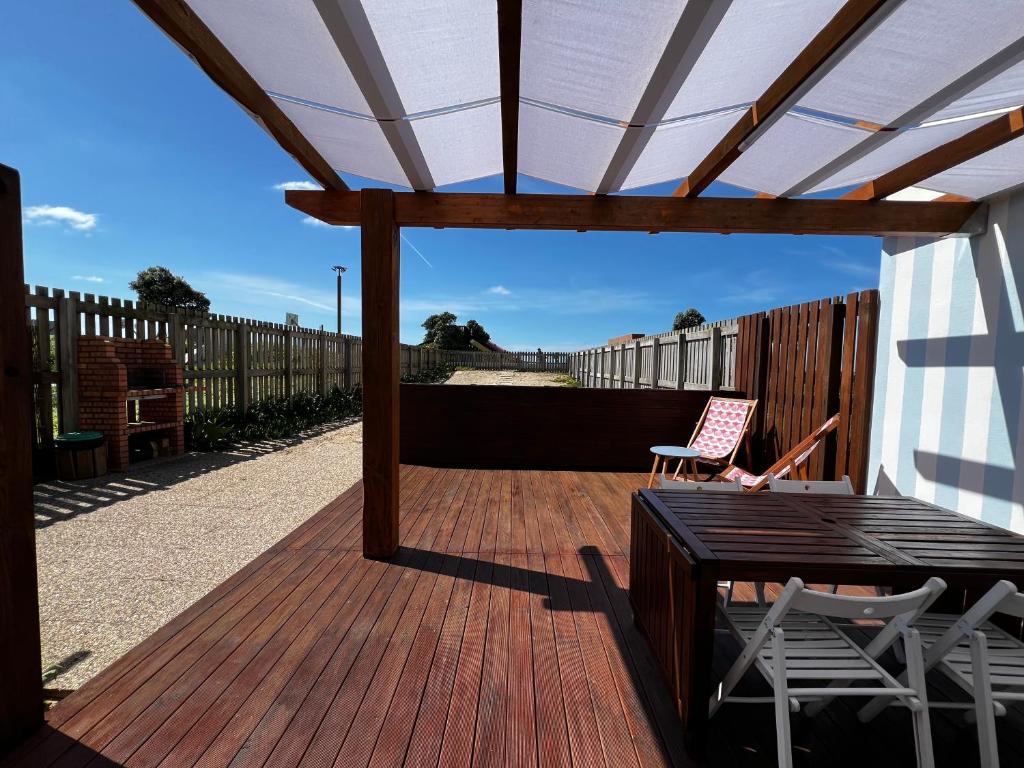 a wooden deck with a pergola and a table and chairs at Avô Moreira Beach House in Póvoa de Varzim