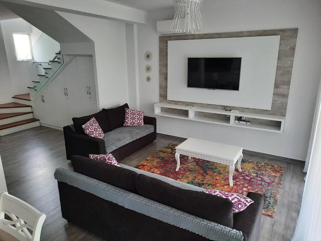 a living room with a couch and a tv at Super Leisure Vila-Plazhi San Pietro, Gjiri i Lalezit in Lalzit Bay