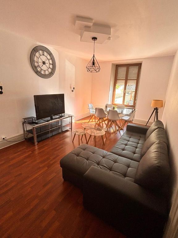 un salon avec un canapé et une table avec des chaises dans l'établissement TK Appartment, à Mulhouse