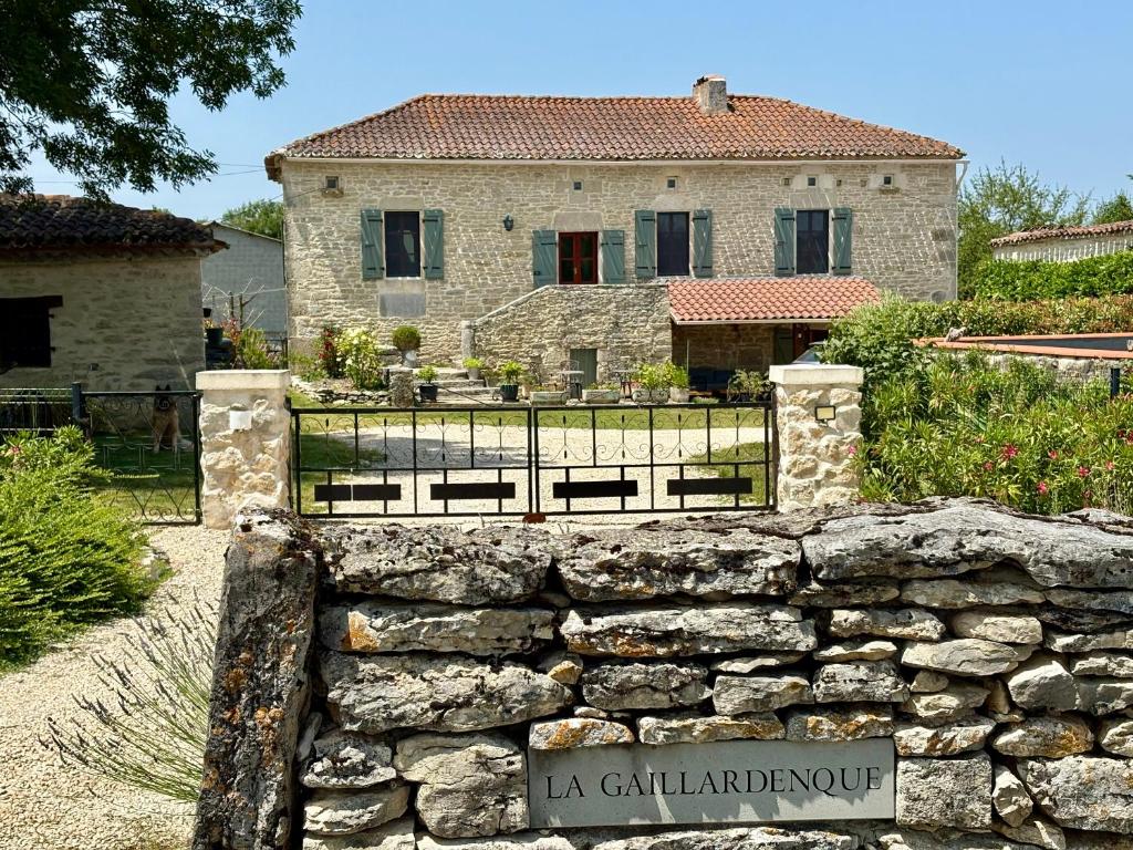 a stone fence in front of a house at La Gaillardenque Gîtes - Farmhouse and Gîte in Floressas