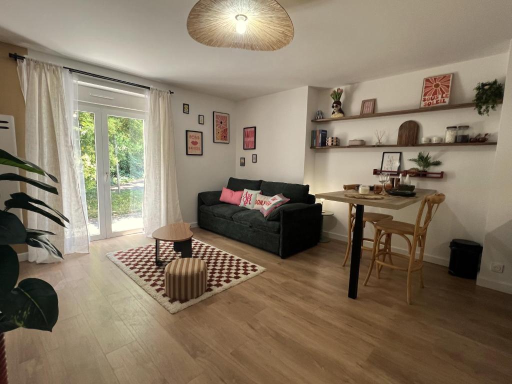 ein Wohnzimmer mit Sofa und Tisch in der Unterkunft Appartement chic & cosy au calme in Albi