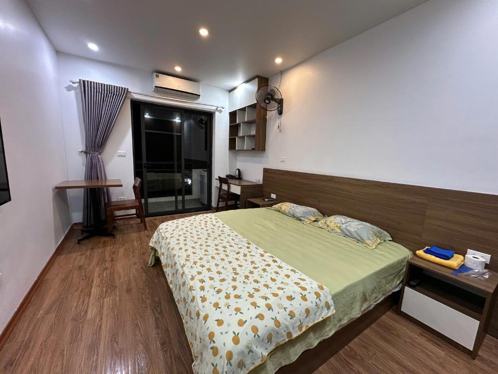a bedroom with a bed and a desk and a window at An Lạc 402MD in Hanoi