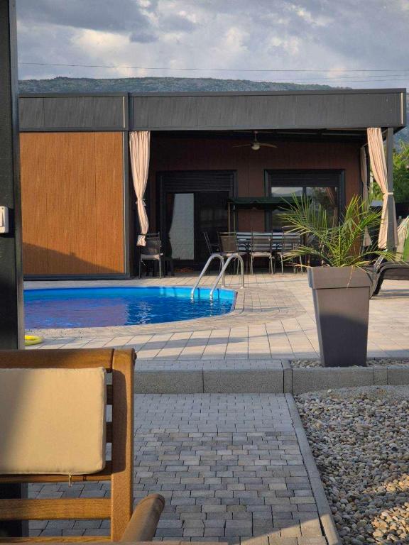 a swimming pool in front of a house at Kuca za odmor B in Kosor