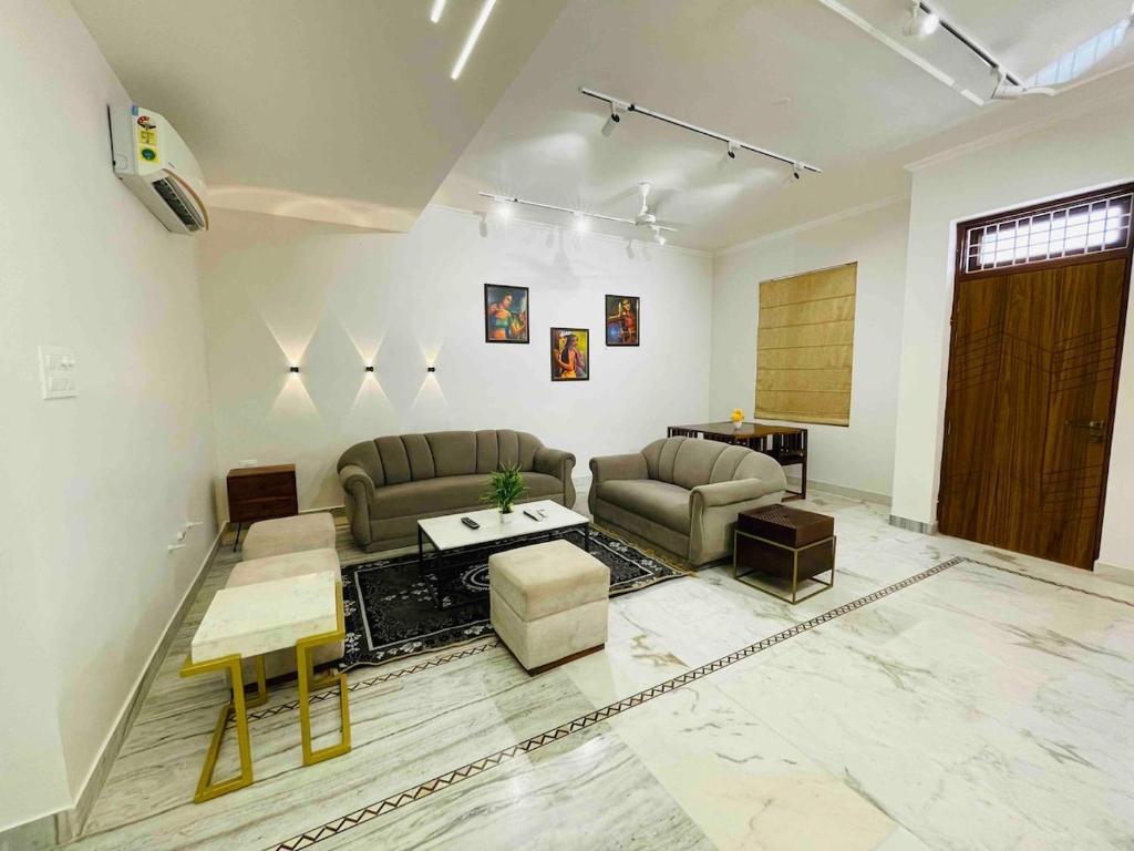 a living room with two couches and a table at 4bhk designer villa near Airport by Akira Homes in Jaipur