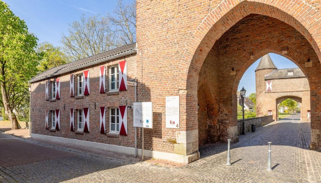a brick building with red and white flags on it at Urlaub im historischen Torschreiberhaus in Xanten